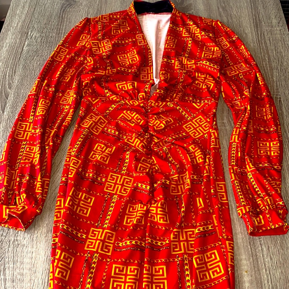 Long sleeve medium sized fitted dress with an opening in the front.
